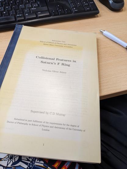 A yellowed cover of a thesis entitled "collisional features in Saturn's f ring by Nicholas Oliver Attree".