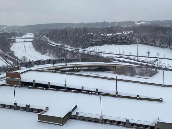 Color image of snow-covered SR 59 Akron, Summit County, Ohio, USA. Image shows the lanes of a downtown expressway covered in snow early morning December 2, 2025, with heavy gray skies overhead and a forecast for more snow.