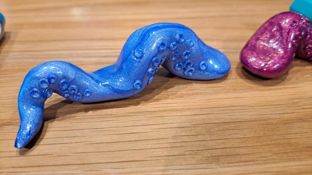 A pair of tentacle brush holders sitting on a desk