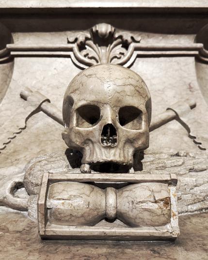 Photo: A skull without teeth on an hourglass