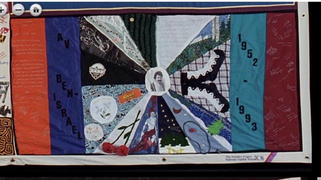 Panel from the quilt with a small picture of a bearded man at the center.