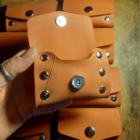 9 petits porte-monnaie en chambre à air rouge brique pâle, assemblés par des rivets, avec fermeture par rivet aimanté
Celui dans ma main est ouvert