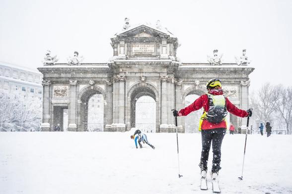 Hombre y mujer esquiando sobre la nieve frente a la Puerta de Alcalá durante la tormenta Filomena en 2021 en Madrid, España (PEPE_GUINEA)