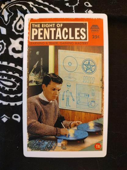 Card from the SciFi Tarot by Todd Alcott.
Eight of Pentacles.
A young man at a working table, working or building a model. On the wall to his left is a blue print.