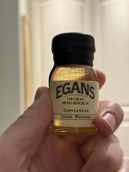 A small taster dram of Egan’s Irish Whisky Conviction . It has a dipped wax top.