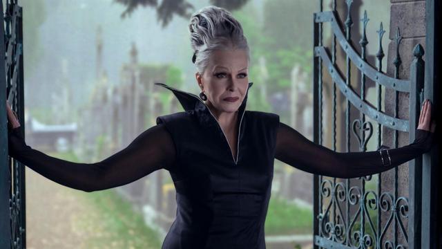 An older woman with silver hair looking very goth.