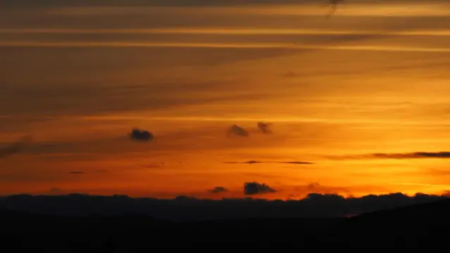 Nach dem Sonnenuntergang leuchtet der Himmel mit ein paar Wölkchen Golden