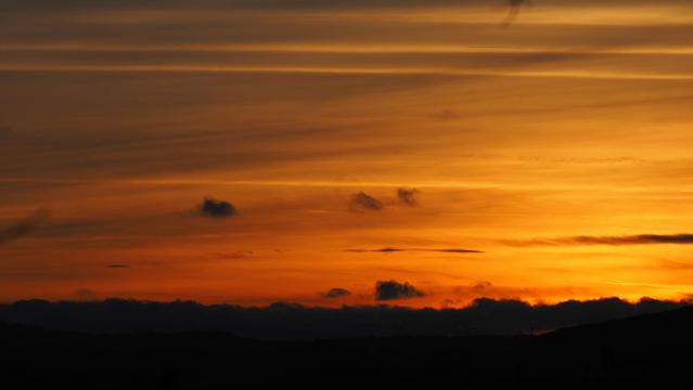 Nach dem Sonnenuntergang leuchtet der Himmel mit ein paar Wölkchen Golden