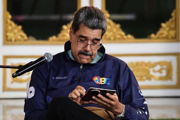 El presidente de Venezuela, Nicolás Maduro, mira su teléefono durante una marcha por el Día del Estudiante, el 21 de noviembre de 2025, en el Palacio de Miraflores, en Caracas. (JESUS VARGAS / Getty Images)