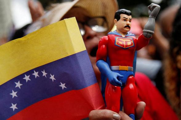 Un simpatizante de Nicolás Maduro sostiene una figura de Super Bigote, el superhéroe inspirado en el mandatario, durante un acto en el Palacio de Miraflores, el 1 de diciembre de 2025. (Leonardo Fernandez Viloria / Reuters)