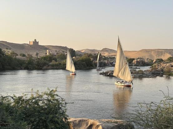 Panorama over de Nijl bij Aswan met drie felukka’s. Links aan de overkant het mausoleum van de Aga Khan. Eigen foto, 2025