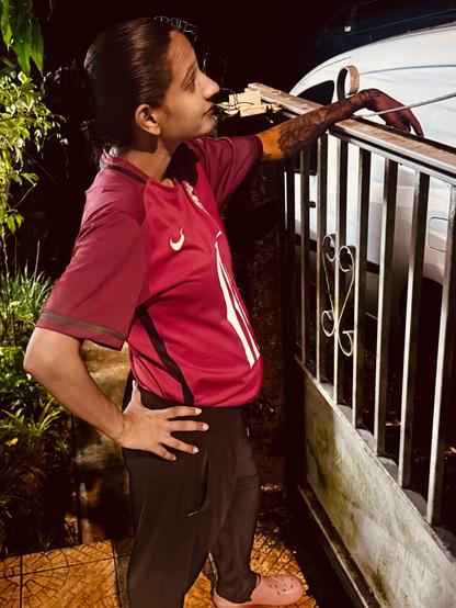 Photo dâune femme, habillĂ© avec un maillot de foot rouge, jogging et crocs, un chignon
Photo of a woman, dressed in a red soccer jersey, jogging and fangs, a bun