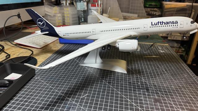 A Lufthansa model airplane is shown from the side, with its logo and branding visible.