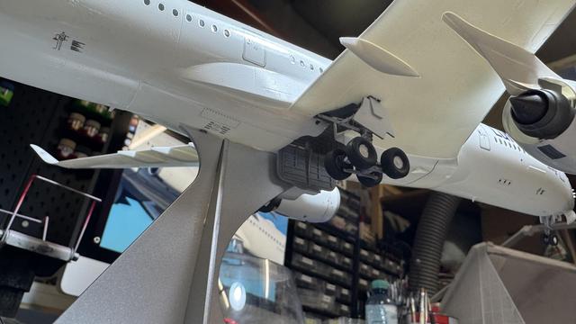 A close-up shot of the landing gear of a model airplane, showing intricate details of the wheels and struts.