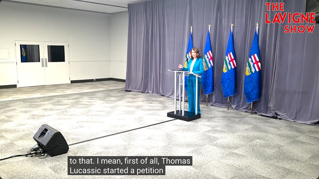 Video shows Alberta Premier Danielle Smith behind a lectern on Day 2 of the UCP's AGM answering a question from Jason Lavigne on November 29th, 2025 after her keynote speech. The Lavigne Show logo is in the top-right corner of the video, and the Closed Captioning reads: "to that. I mean, first of all, Thomas Lucassic[sic] started a petition"
