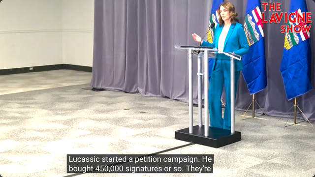 Video shows Alberta Premier Danielle Smith behind a lectern on Day 2 of the UCP's AGM answering a question from Jason Lavigne on November 29th, 2025 after her keynote speech. The Lavigne Show logo is in the top-right corner of the video, and the Closed Captioning reads: "Lucassic[sic] started a petition campaign. He bought 450,000 signature or so. They're"