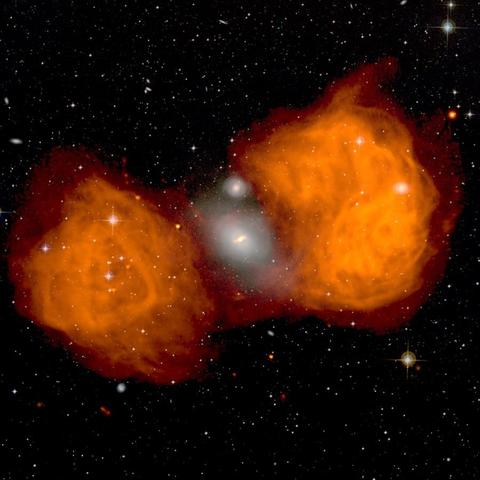 2005 June 28

The Giant Radio Lobes of Fornax A
 * Credit: Ed Fomalont (NRAO) et al., VLA, NRAO, AUI, NSF

Explanation: 
Together, the radio lobes span over one million light years -- what caused them? In the center is a large but peculiar elliptical galaxy dubbed NGC 1316. Detailed inspection of the NGC 1316 system indicates that it began absorbing a small neighboring galaxy about 100 million years ago. Gas from the galactic collision has fallen inward toward the massive central black hole, with friction heating the gas to 10 million degrees. For reasons not yet well understood, two oppositely pointed fast moving jets of particles then developed, eventually smashing into the ambient material on either side of the giant elliptical galaxy. The result is a huge reservoir of hot gas that emits radio waves, observed as the orange (false-color) radio lobes in the above image. The radio image is superposed on an optical survey image of the same part of the sky. Strange patterns in the radio lobes likely indicate slight changes in the directions of the jets. 

Authors & editors: Robert Nemiroff (MTU) & Jerry Bonnell (UMCP)
NASA Official: Amber Straughn Specific rights apply.
NASA Web Privacy, Accessibility, Notices;
A service of: ASD at NASA / GSFC,
NASA Science Activation
& Michigan Tech. U.
