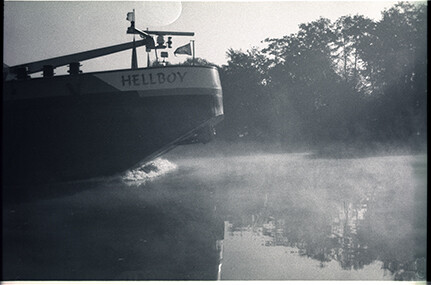 ship with the name Hellboy passing by in the fog on the river Maas
