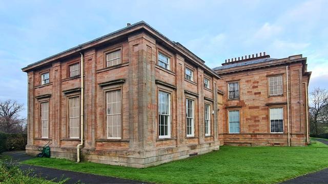 A Georgian era mansion with fake stone windows on one wall.