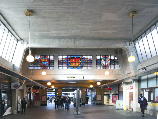 A colour photograph of the interior of Uxbridge tube station with its stained glass windows