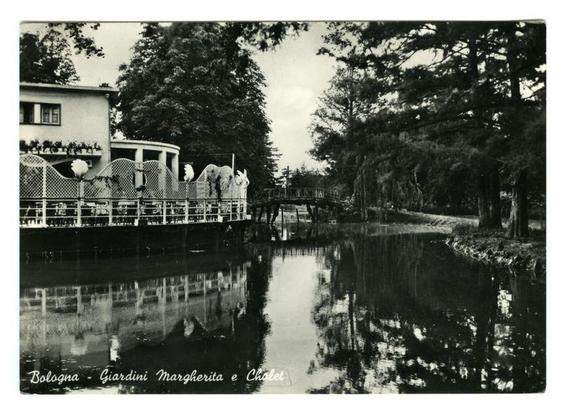 The image is a black and white photograph depicting an outdoor scene with water, trees, and structures. On the left side of the photo stands a building or pavilion adorned with plants on its roof. A bridge spans across the body of water in the center, connecting two wooded areas. The reflection of this structure can be seen clearly on the surface of the calm water below.

The photograph is labeled "Bologna - Giardini margherita e Chalet" at the bottom, indicating that it was taken in Bologna's Margherita Gardens and a chalet within them. This suggests the image captures part of a public park or garden area designed for leisurely strolls and enjoyment. The overall atmosphere is tranquil and picturesque, with natural elements combined harmoniously to create an inviting space.

Additional information about this specific photo can be found at the URL provided: https://images.loener.nl/FerroCandilera/full/6730/6730f06c89b10e7a26bbe1c2.jpg. This image is part of a collection managed by Ferro Candilera, likely showcasing historical photographs or prints related to gardens and outdoor spaces in Bologna.
