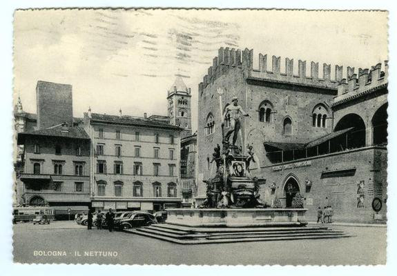 The photograph is a black and white postcard depicting the Piazza Maggiore in Bologna, Italy. Prominently featured is "Il Nettuno," or Neptune's Fountain, an iconic sculpture showing a large statue of Neptuneholding up his trident as if to draw water from it. The fountain stands on a rectangular platform with steps leading down into the center where pools of water are visible.

Behind this central feature rises Palazzo d'Accursio, identifiable by its distinctive tower and Gothic architecture, including pointed arches in windows and decorative stonework around doorways. Other historical buildings surround the square, some adorned with posters on their walls indicating public notices or advertisements from what appears to be several decades ago.

On the left side of the postcard, there are parked cars and a tram, suggesting this photo was taken during an era when automobiles were becoming common but before they dominated urban transportation. Several individuals can also be seen in various states of activity: walking through the square, standing near vehicles, or conversing with others. The sky is overcast, casting soft shadows on the ground.

The postcard bears a caption "BOLOGNA - IL NETTUNO" at its bottom edge and shows signs of age such as creases and light fading in certain areas.
