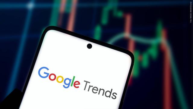 Ein Handydisplay, auf dem „Google Trends“ angezeigt ist, im Hintergrund ein Graph. (Foto: IMAGO, IMAGO/Zoonar)