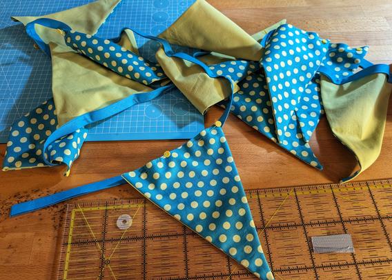 dotted turqoise/lime green and lime green triangle flags pinned together on bright blue bias tape