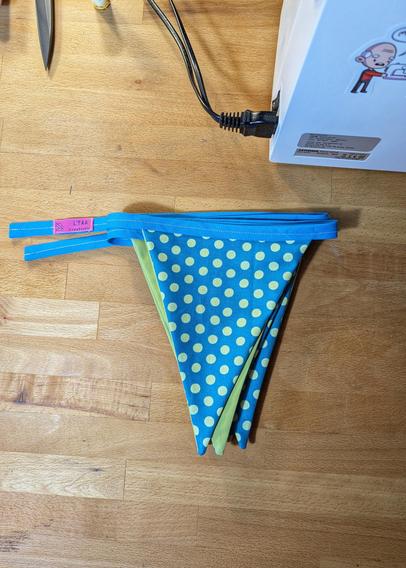 a folded stack of turqoise/lime green traingle flags