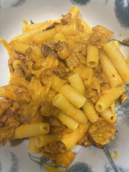 A plate of pasta with orangey sauce