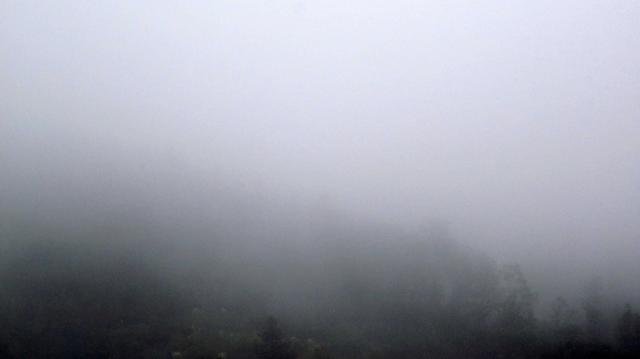 Fotografía en color de un monte envuelto en niebla