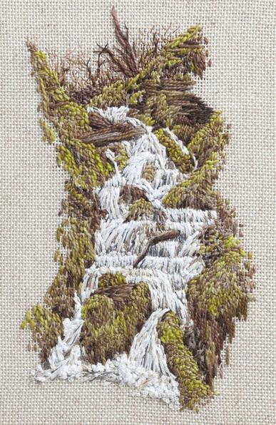 Stitched artwork depicting a waterfall made up of several small falls. The water flows over moss covered rockks and the fall is surrounded by grass and moss