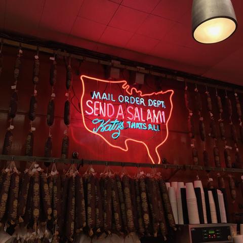 The famous neon sign in Katz's Deli that reads "Mail Order Dept. / Send a Salami / Katz's that's all" inside an outline of the continental United States