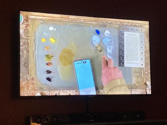 Photo of a TV showing ChromaMagic and Paul mixing a blue for a sky.