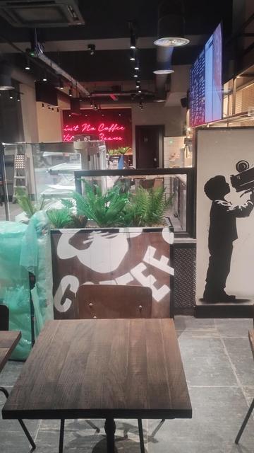 Looking in through the window of the partly completed new chain coffee shop at night