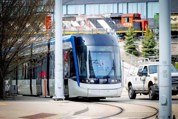Photo taken outside of the ION train on King Street, passing by at the same moment as a traditional freight train does in the background.