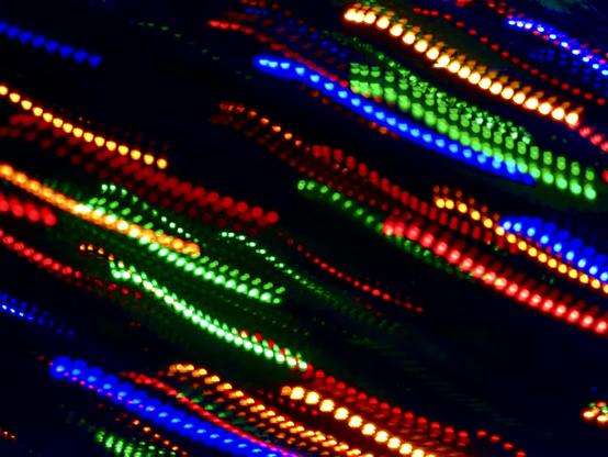 Colorful diagonal streaks of LED lights on a dark background.