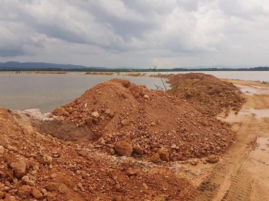 Piles of soil at the interface of a road and a water body. Photograph by the authors.
