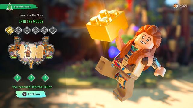 The screenshot shows a level-completion screen from LEGO Horizon Adventures on PS5. On the left, a green banner with a pine-tree icon reads “Sacred Lands,” followed by the mission title “Rescuing The Nora” and the chapter segment “Into the Woods.” Beneath it is a row of six collectible brick icons, with the first one glowing gold to indicate it was earned. Below that, an illustrated badge displays four character silhouettes; one of them—Teb the Tailor—is revealed and fully lit to show he has been rescued, matching the text below: “You rescued Teb the Tailor.” Three additional unlock icons appear as green diamonds with question marks. At the bottom left, a blue button prompt says “X Continue.” On the right, a joyful LEGO Aloy leaps into the air holding a huge shimmering golden LEGO brick, her braids flying as warm sunlight flares behind her. This screen celebrates mission progress, golden brick rewards, and rescued NPCs—key elements of the game’s lighthearted, collectible-driven LEGO reinterpretation of the Horizon universe.