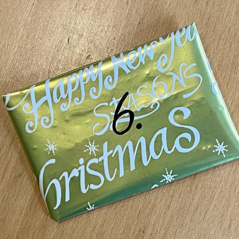 Eine in goldenes Weihnachtspapier verpackte ATC mit der Nummer 6.
