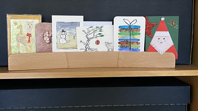 Sechs ATC in einer Postkartenschiene im Regal.