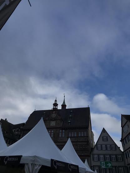 Tübinger Rathaus halb verdeckt von spitzen Zelten, auf einem steht Chocoidea