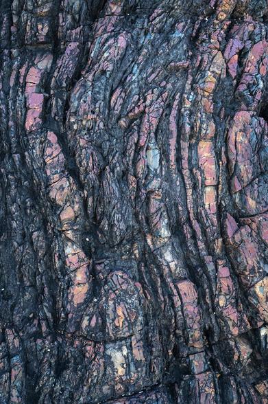 rocks closeup with curvy lines and weird colors - pink and black and slightly magenta