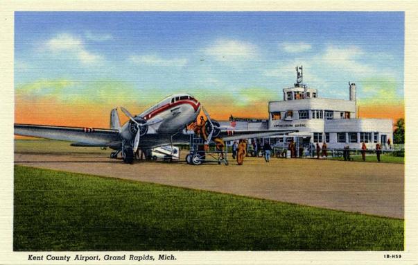 postcard is a classic linen-era illustration showing a Douglas DC-3 parked on the ramp in front of the original Kent County Airport terminal. Ground crew members are servicing the aircraft while passengers and airport staff gather near the entrance. The scene captures the streamlined, modern aesthetic associated with late-1930s commercial aviation and reflects the airport's early role in connecting Grand Rapids with regional air service.