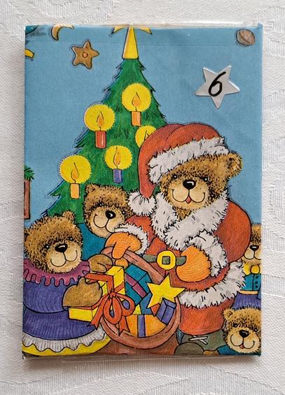 Umschlag aus weihnachtlichem Geschenkpapier, auf dem niedliche Weihnachtsbären mit Geschenken vor einem Tannenbaum zu sehen sind. Darauf ein kleiner sternförmiger Aufkleber mit der Nummer 6.