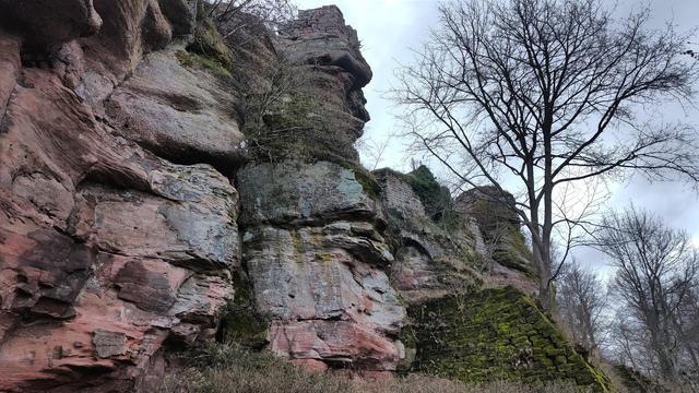 depuis la cour du chateau, la vue sur le flanc rocheux et les structures au dessus.