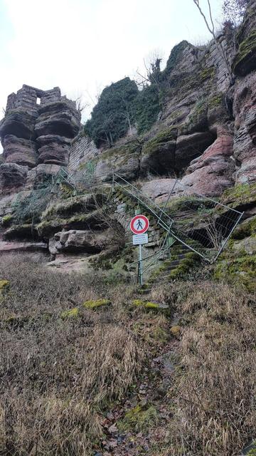 le début de l'escalier avec un panneau d'interdiction et une grille qui barre l'entrée.