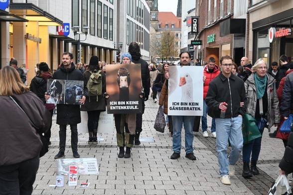 Aktivis stehen in der Innenstadt und halten Schilder mit Tieren darauf und Sprüchen wie "Kein Lammbraten" die Stadt ist sehr voll.