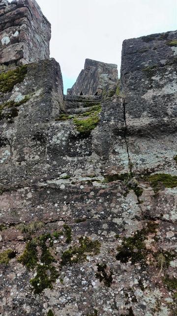 en haut d'une façade rocheuse, un escalier taillé dans la pierre.