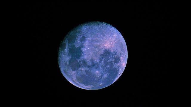 A near full moon, with parts of the mare in different colours, and Tycho's spray in magenta.